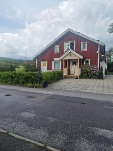 a red building with a driveway in front of it at Cosig house in Nygård