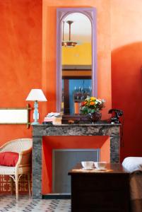 een woonkamer met een open haard en een spiegel bij Les Chambres des Dames in Rieux-Minervois