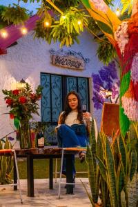 Eine Frau, die an einem Tisch vor einem Gebäude sitzt. in der Unterkunft Cabañas Villa del Prado in Gigante