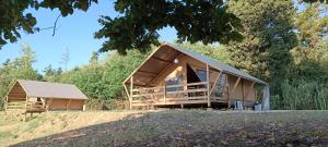 una casa con tetto di gambero su una collina di Glamping Podere Poggiagrilli a San Gervasio