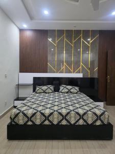 a bedroom with a bed with a black and gold headboard at Bahria enclave sect N in Islamabad