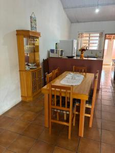 a dining room with a wooden table and chairs at Casa da Voh in Ilha Comprida