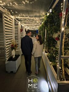 un uomo e una donna che scendono da una scala mobile con luci di HOME 3 BED Aparthotel a Bisceglie