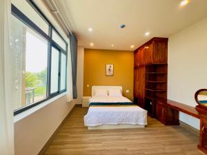 a bedroom with a bed and a large window at Ruby Hotel in Nhơn Trạch