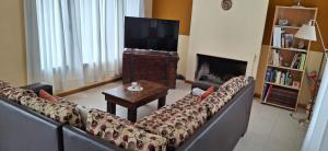a living room with a couch and a flat screen tv at Patagonia Adriano in Caviahue