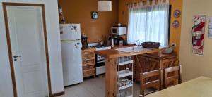 a kitchen with a white refrigerator and a counter top at Patagonia Adriano in Caviahue