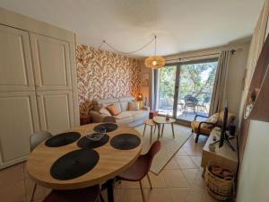 a living room with a table and a couch at Golf apartment in Saumane-de-Vaucluse