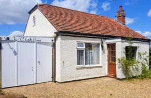 una piccola casa bianca con garage di Littleholme a Potter Heigham