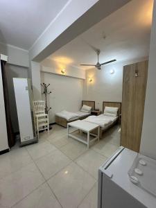 a living room with two beds and a table at فندق حمورابي Hammurabi Hotel in An Nāşirīyah
