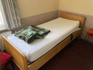 a bed with white sheets and a blanket on it at Het werkhuis, terug in de tijd in Uden