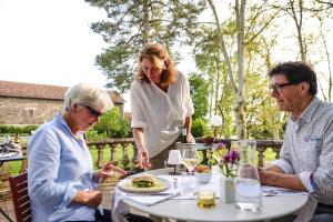 three older people sitting around a table eating food at Oh, le château! in Almayrac