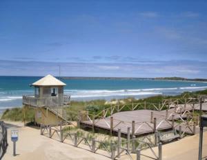 a building on the beach with the ocean in the background at Roshnier Apartment in Warrnambool