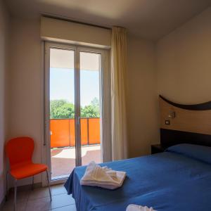 a bedroom with a bed and a sliding glass door at Tropicana Residence in Lido degli Estensi