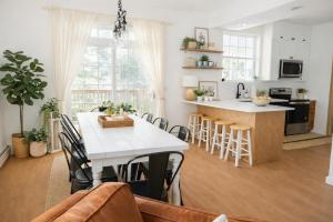 a kitchen and living room with a white table and chairs at Catskill Cabin with Firepit & Indoor Jacuzzi Tub in Catskill