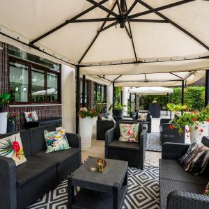 an outdoor patio with couches and tables at Tropicana Residence in Lido degli Estensi