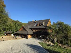 a large wooden house on a gravel road at Koliba Studencka Politechniki Warszawskiej in Caryńskie