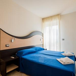 a bedroom with a blue bed and a window at Tropicana Residence in Lido degli Estensi +55 photos