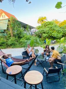 a group of people sitting in chairs and tables at The 10 Club Hostel & Tiny Villas in Thong Sala