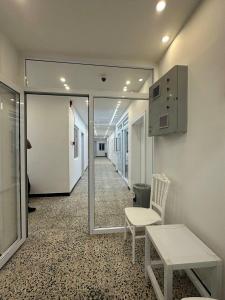 a hallway with a mirror and a table and a chair at فندق حمورابي Hammurabi Hotel in An Nāşirīyah