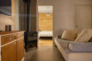 ein Wohnzimmer mit Sofa und eine Küche in der Unterkunft Baitèl de Sòt e Sura - Appartamenti in Gromo