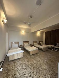 a room with three beds in a room with at فندق حمورابي Hammurabi Hotel in An Nāşirīyah