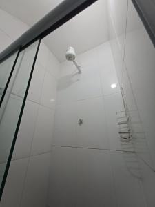una doccia con una luce in una parete bianca di Studio Com Ar Condicionado na Manoel Novais a Serrinha