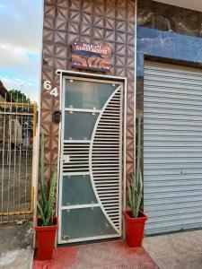 una porta di fronte a un edificio con due piante di Studio Com Ar Condicionado na Manoel Novais a Serrinha Altre 17 foto