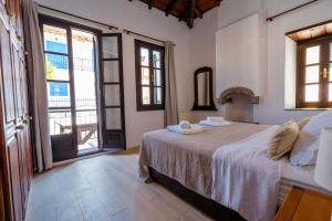 una camera da letto con un letto in una stanza con finestre di The Dream House Skiathos a Città di Skiathos Altre 10 foto