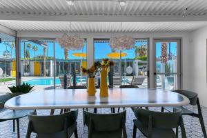 una sala da pranzo con tavolo, sedie e piscina di Limon Palm Springs A Luxury Boutique Hotel a Palm Springs