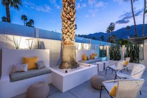 un patio con una palma e sedie di Limon Palm Springs A Luxury Boutique Hotel a Palm Springs
