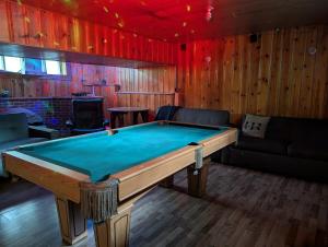 a room with a pool table and a couch at Chalet Lumière in Rawdon