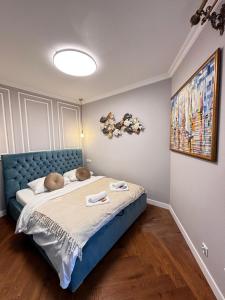 a bedroom with a large bed with a blue headboard at Pratum Pink&Blue Mikołajki - Apartament 37 Stone&Wood in Mikołajki