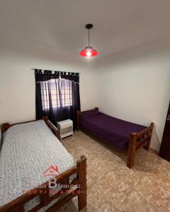 a bedroom with two beds and a window at Departamento del Tuyu in Mar del Tuyú