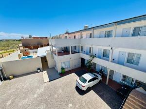 een auto geparkeerd op de binnenplaats van een gebouw bij Complejo Brisas Místicas in Las Grutas