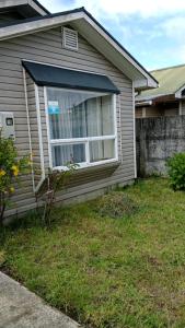 una casa con una finestra sul lato di Casa Amayita 2 a Puerto Varas
