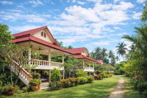 a house with a red roof and a yard at Labelle villa koh phangan in Ko Phangan