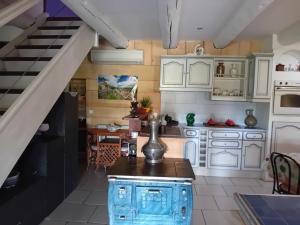 a kitchen with white cabinets and a table at CAMPA'Gite in Toiras
