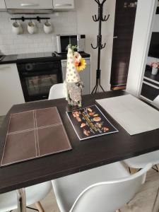 een eettafel met een vaas met een bloem erop bij DAVID Residence in Cavnic +4 foto's