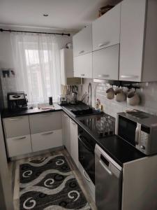 een keuken met witte kasten en een kookplaat oven bij DAVID Residence in Cavnic