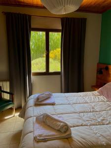 a bedroom with a large bed with towels on it at Hostel Nakel Yenu in El Calafate +7 photos