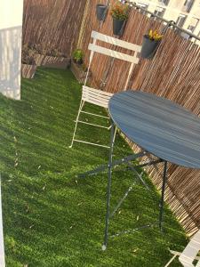 a blue table and a chair sitting on the grass at Appart Cosy Centre ville -proche gare in Châtellerault