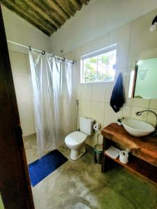 a bathroom with a toilet and a sink and a window at Refúgio do Boto, casa nova em meio a natureza rústica in Alto Paraíso de Goiás +52 photos