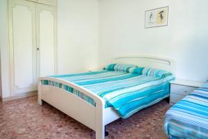 a bedroom with a bed with blue and white sheets at Marcelli, trilocale con balcone e posto auto in Marcelli