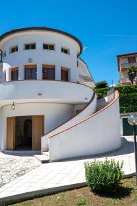 a large white building with a staircase in front of it at Marcelli, trilocale con balcone e posto auto in Marcelli