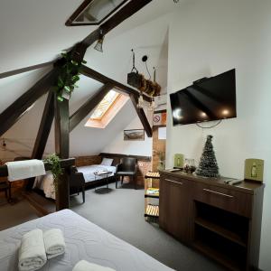 una camera da letto con un letto e una TV a schermo piatto di Hedonia Luxury Rooms a Pirot