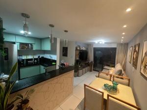a kitchen and living room with a table and a counter at Quarto lovina e fest verão in Cabedelo