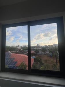 a window with a view of a roof at Quarto lovina e fest verão in Cabedelo +1 photo