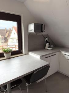 una piccola cucina con tavolo e finestra di Helles & Modernes Apartment in Heilbronn a Heilbronn Altre 11 foto