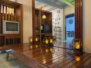 een woonkamer met een houten tafel met kaarsen erop bij The Memory Hostel Trat in Trat