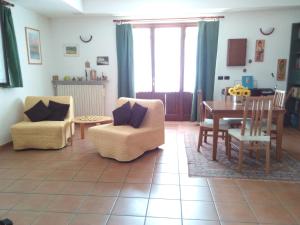 sala de estar con sillas, mesa y comedor en Casa Statiella, en Acqui Terme